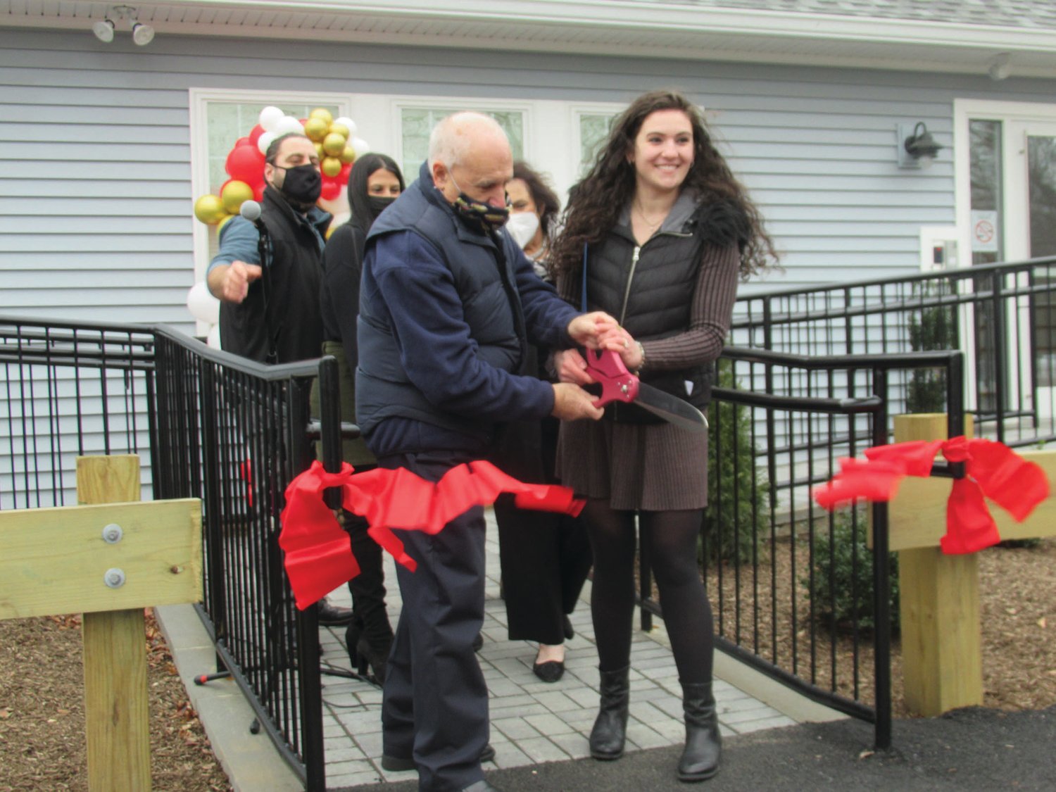 SUPER SNIP: Mayor Joseph Polisena and Dr. Jessica DiRocco make it official by cutting the ribbon during the grand opening of Johnston’s newest business.